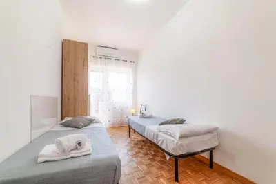 two beds in a room with white walls at Giorgia Flat - Tiburtina Train Station - Wi-Fi in Rome