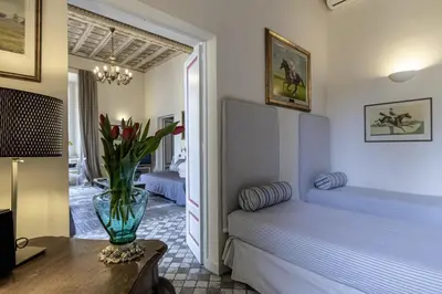 a bedroom with a bed and a vase of flowers on a table at Piazza della Maddalena view in Rome