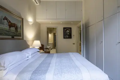 a bedroom with a large bed with a painting of a horse at Piazza della Maddalena view in Rome