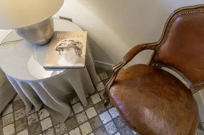 a book sitting on a chair next to a table at Piazza della Maddalena view in Rome