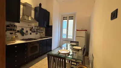 a kitchen with a glass table and a refrigerator at Valentina Suite Colosseo in Rome