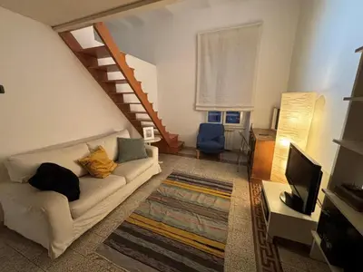 a living room with a white couch and a staircase at Valentina Suite Colosseo in Rome