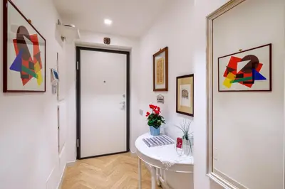a hallway with a white door and a table with flowers at Corte Trastevere Living in Rome