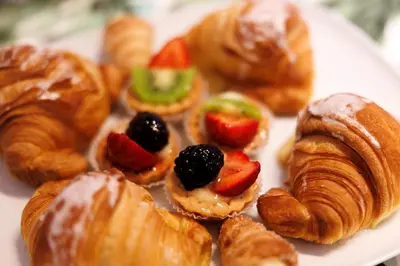 a plate of pastries and croissants with fruit on it at Corte Trastevere Living in Rome