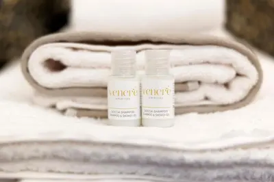two bottles of sunscreen sitting on top of towels at Corte Trastevere Living in Rome