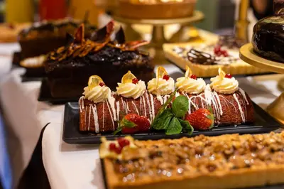 a variety of cakes and pastries on a table at HT6 Hotel Roma in Rome