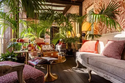 a bedroom with a bed and chairs and plants at HT6 Hotel Roma in Rome