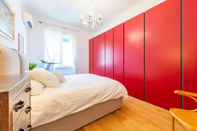 a bedroom with red cabinets and a white bed at Casa Maria al Flaminio in Rome