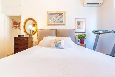 a bedroom with a large white bed and a mirror at Casa Maria al Flaminio in Rome