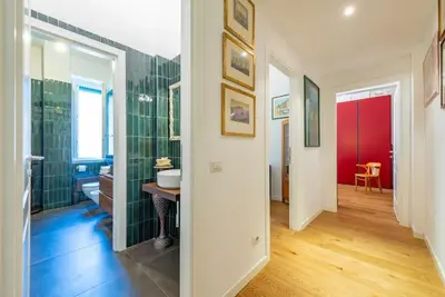 a bathroom with green tiled walls and a red door at Casa Maria al Flaminio in Rome