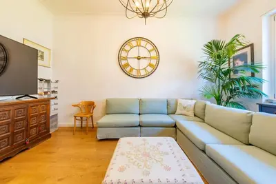 a living room with a couch and a clock on the wall at Casa Maria al Flaminio in Rome