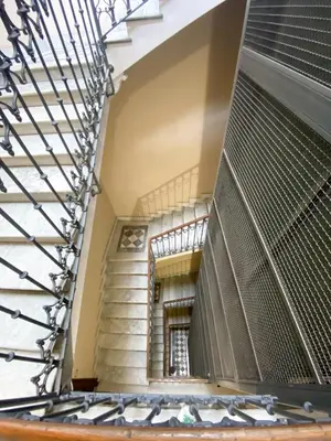 a staircase in a building with a metal railing at JHHIT - In the heart of Rome near the Colosseum in Rome