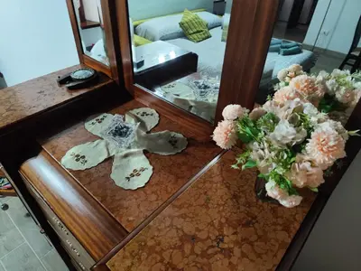 a mirror with a cross on a table with flowers at Casa Ludovica Trastevere in Rome