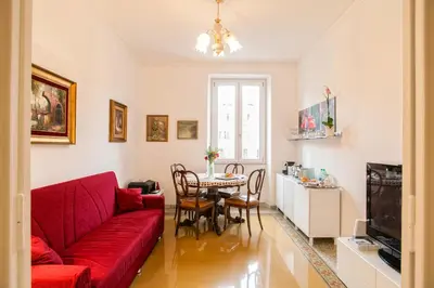 a living room with a red couch and a table at Vatica B&B Roma in Rome