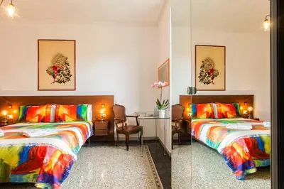 a bedroom with a colorful bed and a red couch at Vatica B&B Roma in Rome