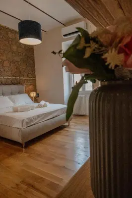 a bedroom with a bed and a vase with flowers at Home Holiday Rome - San Lorenzo in Rome