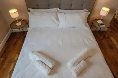 a large white bed with two white towels on it at Home Holiday Rome - San Lorenzo in Rome