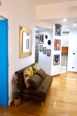 a living room with a brown couch and pictures on the wall at Granma Apt in Rome