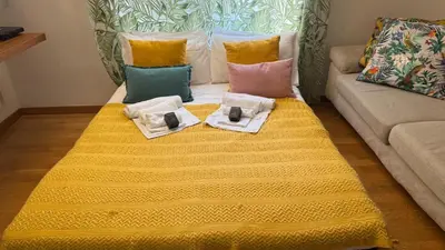 a couch with a yellow blanket and pillows on it at Granma Apt in Rome