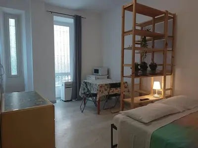 a room with a bed and a desk with a ladder at Monolocale vicino metro Libia in Rome