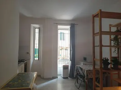 a kitchen with two windows and a table and a ladder at Monolocale vicino metro Libia in Rome