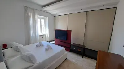 a bedroom with a bed and a flat screen tv at Elegante Appartamento Vaticano Lattanzio in Rome