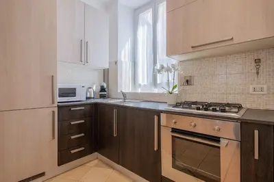 a kitchen with wooden cabinets and a stove top oven at Happy Home in Rome