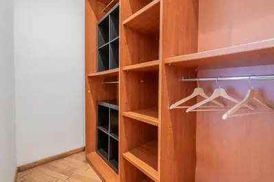 a walk in closet with wooden shelves and hangers at Happy Home in Rome