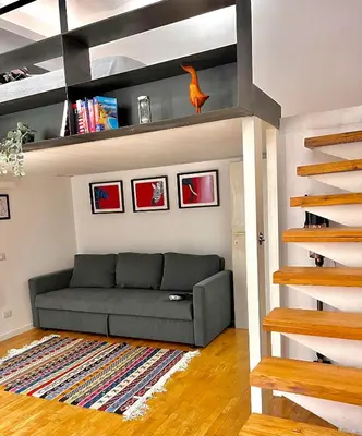 a living room with a couch in a loft bed at Silla Studiò - piccolo appartamento a due passi dal Vaticano in Rome