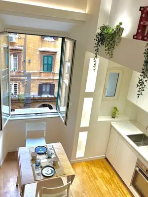 a small kitchen with a table and a window at Silla Studiò - piccolo appartamento a due passi dal Vaticano in Rome