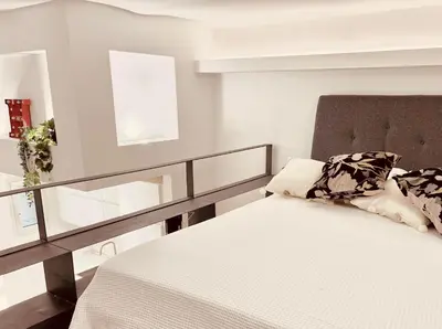 a bedroom with a white bed with a glass railing at Silla Studiò - piccolo appartamento a due passi dal Vaticano in Rome