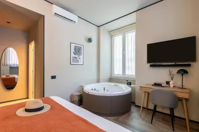 a bedroom with a tub and a bed and a tv at San Giovanni Luxury Rooms in Rome