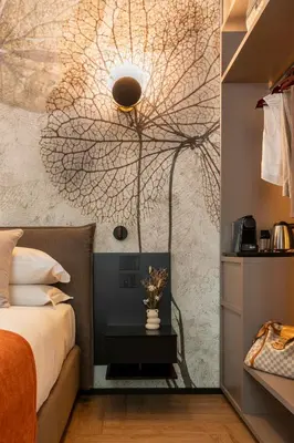 a bedroom with a bed and a wall with a tree mural at San Giovanni Luxury Rooms in Rome
