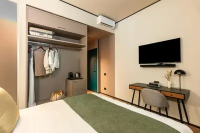 a bedroom with a bed and a desk and a tv at San Giovanni Luxury Rooms in Rome