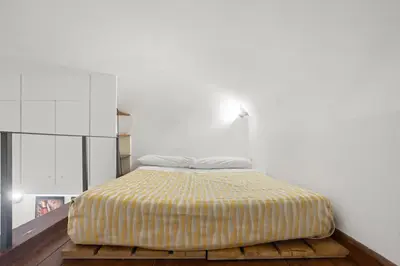 a bed in a room with a white wall at Pretorius Design Loft - Near Termini Station by RHR in Rome