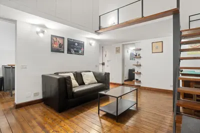 a living room with a black leather couch and a glass table at Pretorius Design Loft - Near Termini Station by RHR in Rome