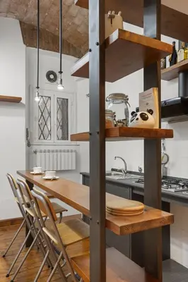 a kitchen with a wooden table and chairs at Pretorius Design Loft - Near Termini Station by RHR in Rome