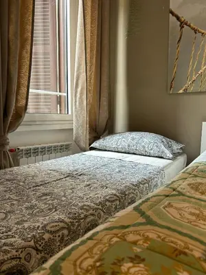 a bedroom with two beds and a window at Casa di Egeria al Colosseo in Rome