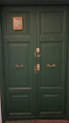 two green doors in a room with at Casa di Egeria al Colosseo in Rome