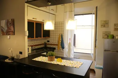 a kitchen with a black counter top and a refrigerator at Casa di Egeria al Colosseo in Rome