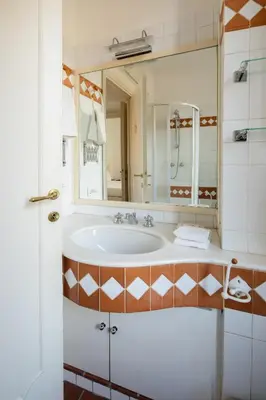 a bathroom with a sink and a large mirror at Casa Mandes Spanish Steps in Rome