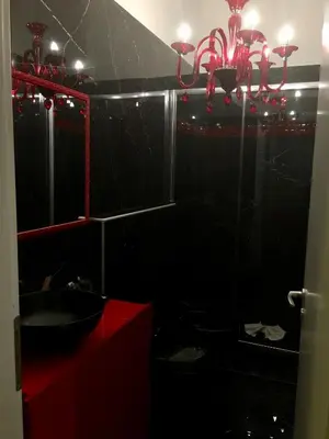 a bathroom with a red sink and a black wall at B&B Roma Royal Residence in Rome
