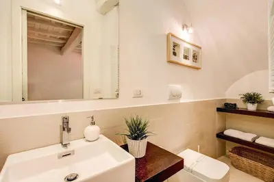 a bathroom with a white sink and a mirror at YH Suite in Rome