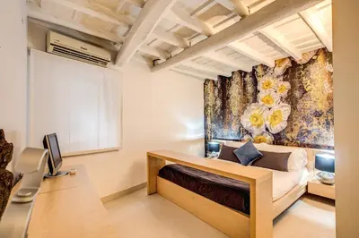 a bedroom with a bed and a wall with a flower mural at YH Suite in Rome