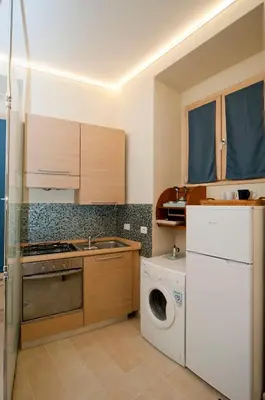 a kitchen with a washing machine and a washer at Silenzioso Monolocale in Zona Parioli in Rome