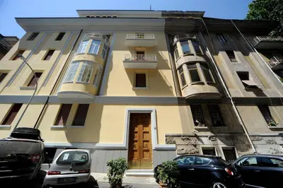 a yellow building with cars parked in front of it at Silenzioso Monolocale in Zona Parioli in Rome