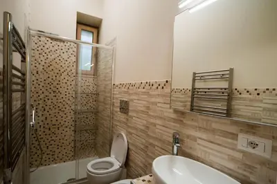 a bathroom with a toilet and a sink and a mirror at Silenzioso Monolocale in Zona Parioli in Rome