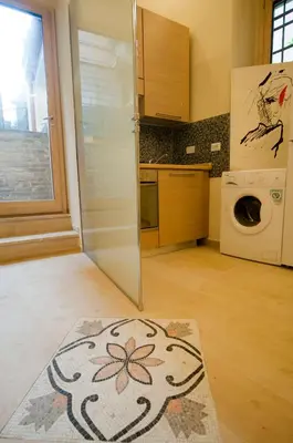a kitchen with a refrigerator and a washing machine at Silenzioso Monolocale in Zona Parioli in Rome