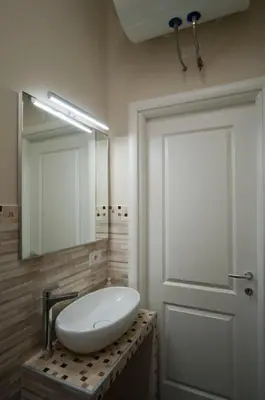 a bathroom with a white sink and a mirror at Silenzioso Monolocale in Zona Parioli in Rome