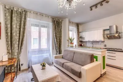 a living room with a couch and a kitchen at Maison St Camillo Rome Centre in Rome